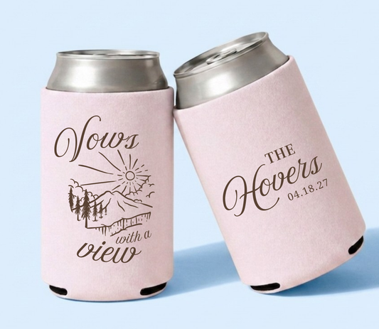 Blush pink personalized wedding can coolers featuring mountain landscape artwork, "Vows with a View," custom family name Hovers, and wedding date.