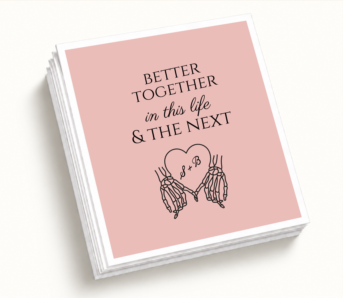 Personalized blush pink Better Together wedding napkin featuring black skeleton hands holding a heart with S and B initials and in this life and the next wording.