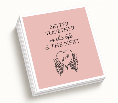 Personalized blush pink Better Together wedding napkin featuring black skeleton hands holding a heart with S and B initials and in this life and the next wording.