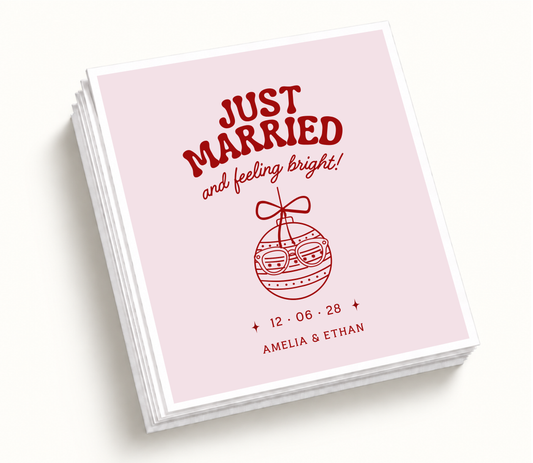 Personalized Just Married And Feeling Bright Christmas wedding napkins featuring blush pink background, red ornament illustration, custom couple names, and wedding date.