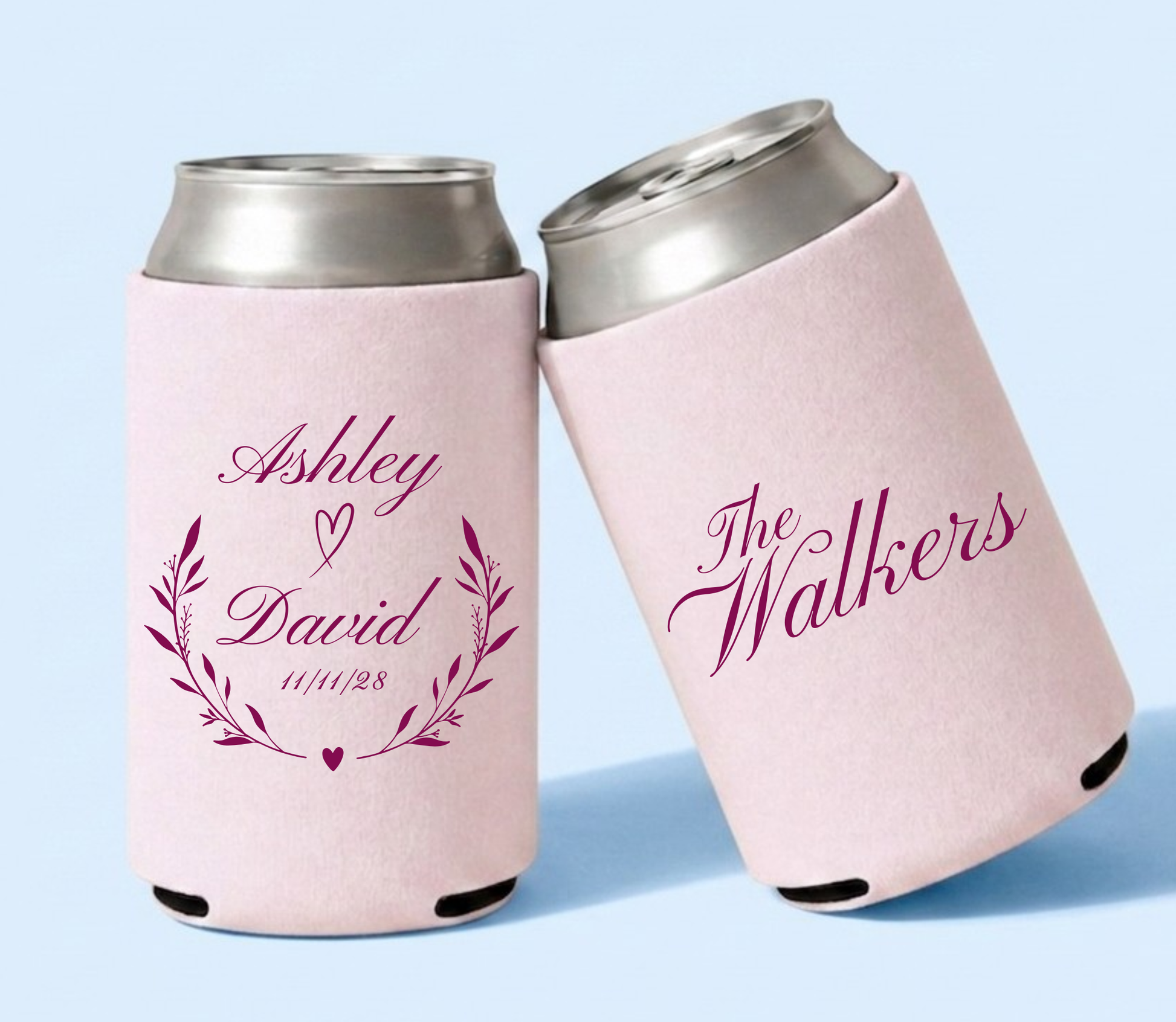 Personalized blush pink wedding can coolers featuring Ashley and David names framed by botanical branches and heart details with The Walkers family name in berry pink lettering.