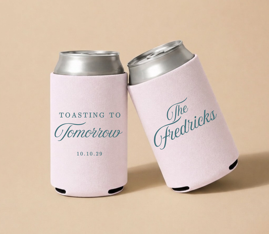 Blush pink personalized foam wedding can coolers featuring "Toasting to Tomorrow" design, custom Fredericks family name, and wedding date October 10, 2029.