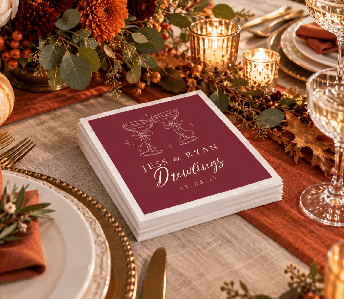 Custom fall wedding napkins with champagne glasses, decorative bows, and elegant ivory typography.