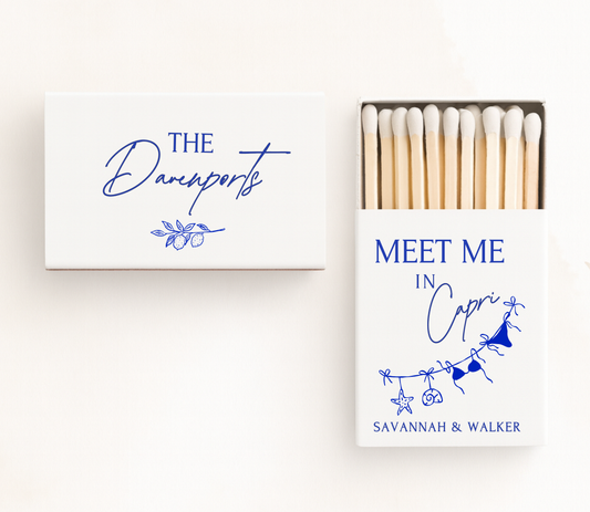 Personalized Capri wedding matchboxes featuring elegant blue typography, Mediterranean-inspired illustrations, and custom wedding names.