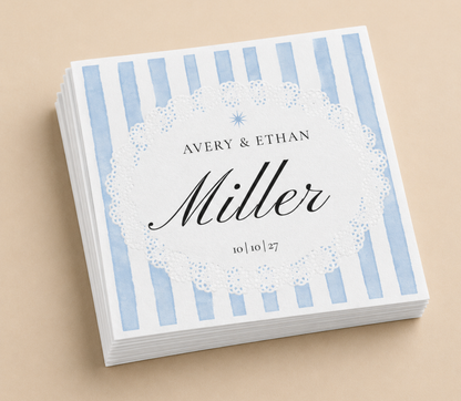 Personalized blue striped wedding napkins with custom names, wedding date, and black script typography on white paper napkins