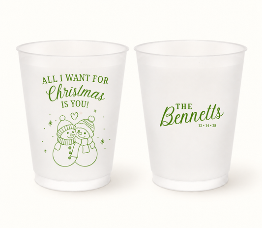 Personalized All I Want Christmas wedding frosted cups featuring snowman holiday design with custom couple names, family surname, and wedding date.