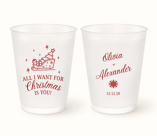 Personalized All I Want Christmas wedding frosted cups featuring a holiday sleigh design with custom couple names and wedding date.