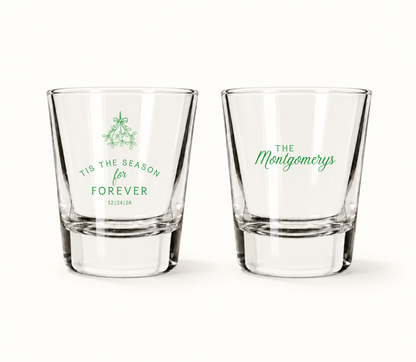 Personalized Tis The Season For Forever Christmas wedding shot glasses featuring mistletoe artwork, custom family name, and wedding date.
