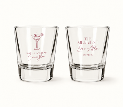 Personalized Merriest Ever After Christmas wedding shot glasses featuring festive cocktail artwork, custom couple names, and wedding date.