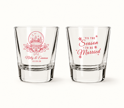 Personalized Tis The Season To Be Married Christmas wedding shot glasses featuring snow globe artwork, custom couple names, and wedding date.
