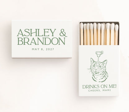 White personalized cocktail cat wedding matchboxes featuring a custom cat illustration with a cocktail glass, elegant green serif typography, couple names, wedding date, and premium safety matches.
Personalized cocktail cat wedding matchbox featuring a custom cat illustration and elegant serif typography.
Custom cat wedding matchbox with cocktail artwork, couple names, and wedding date.