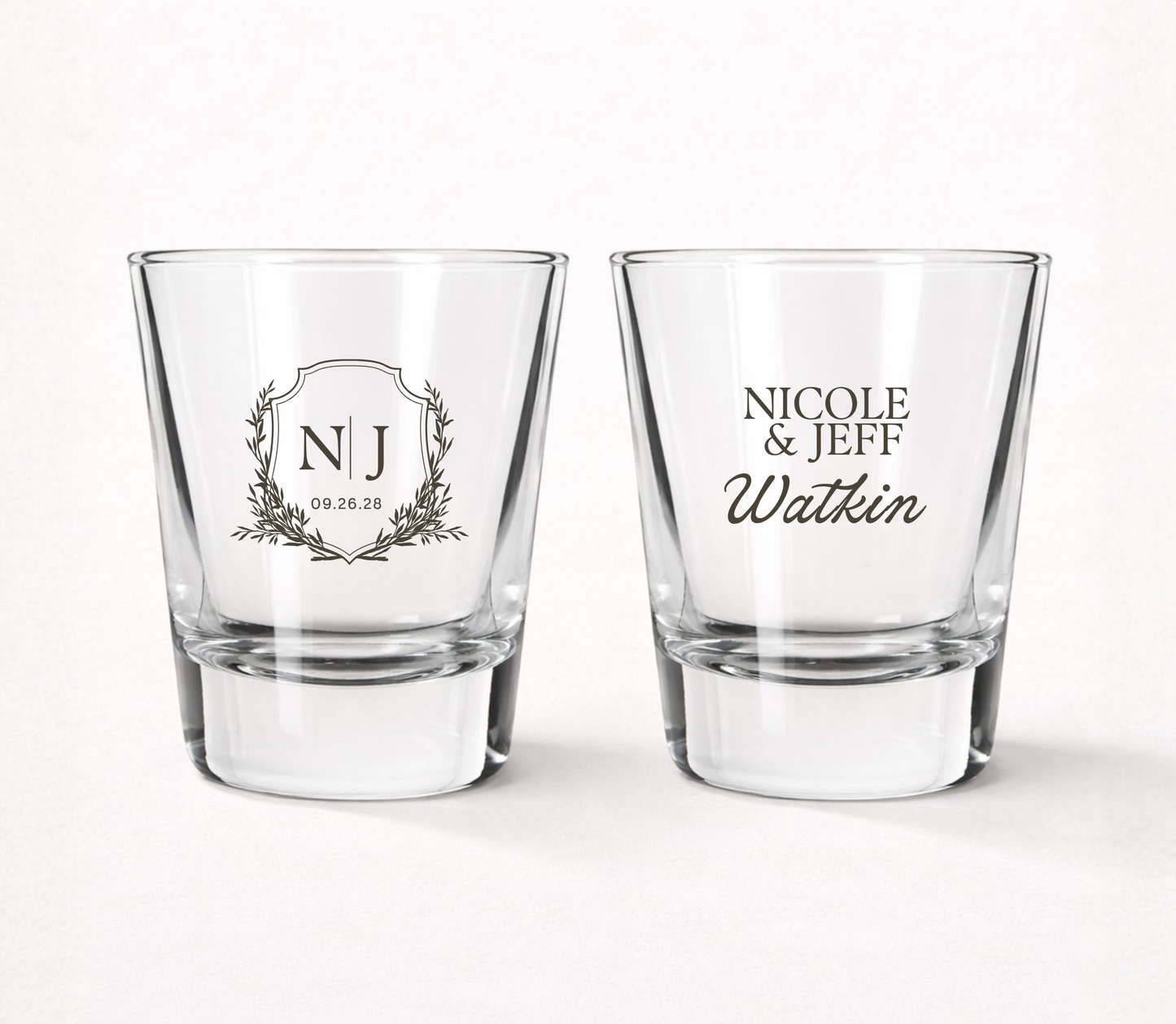 Personalized Monogram Crest wedding shot glasses featuring custom initials, couple names, family name, and wedding date in an elegant crest design.