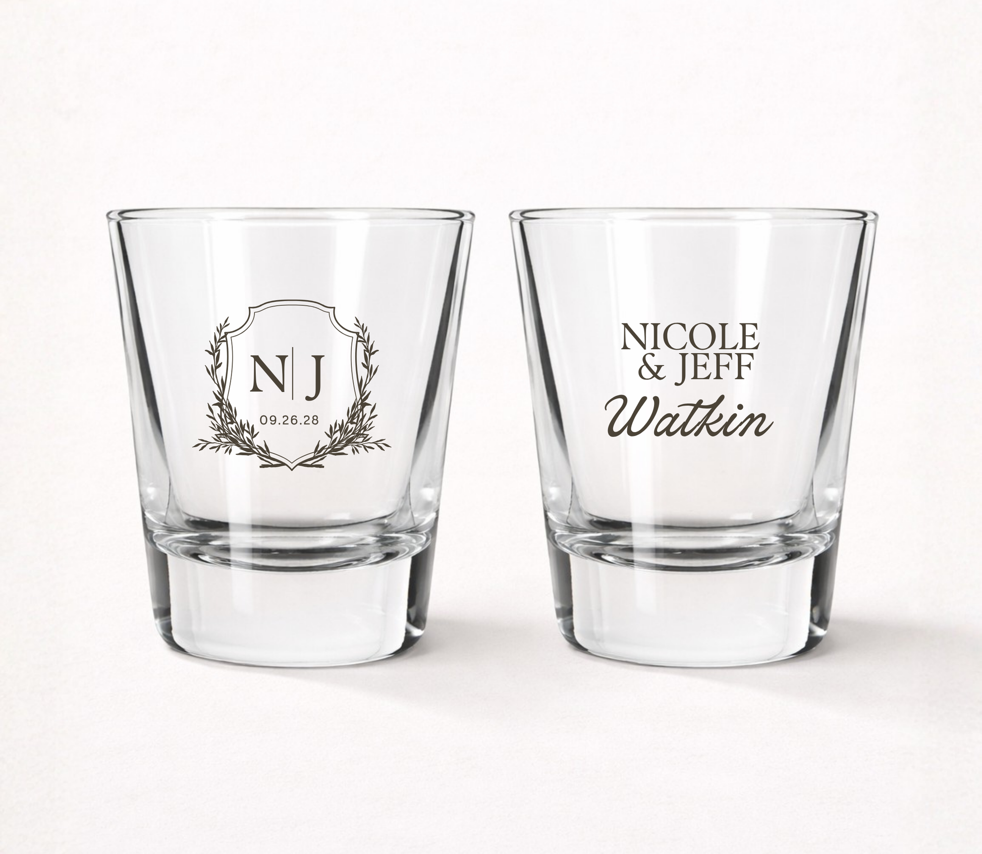 Personalized Monogram Crest wedding shot glasses featuring custom initials, couple names, family name, and wedding date in an elegant crest design.