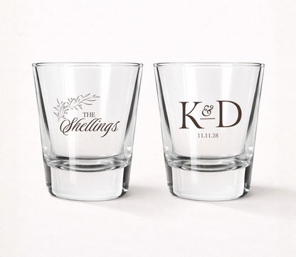 Personalized Shellings Monogram wedding shot glasses featuring custom family name, initials, wedding date, and elegant botanical accents.