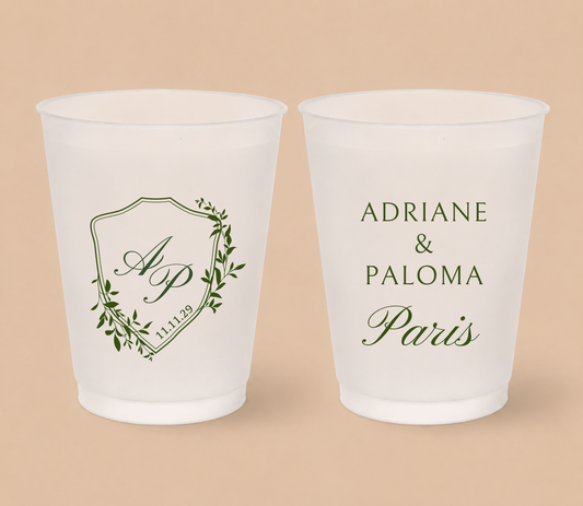 White frosted wedding cups featuring a botanical crest with custom initials AP, wedding date, and personalized names Adriane and Paloma Paris.
