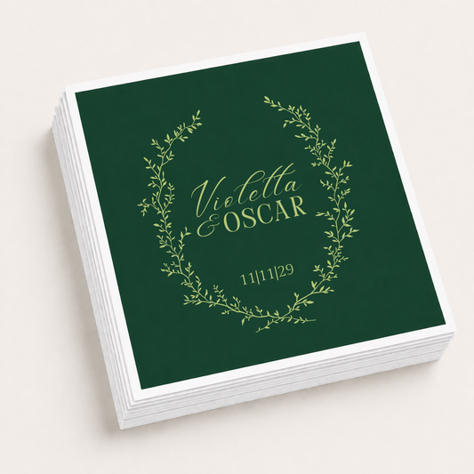 Dark green personalized wedding cocktail napkins featuring a delicate botanical wreath with custom couple names Violetta and Oscar and wedding date.
