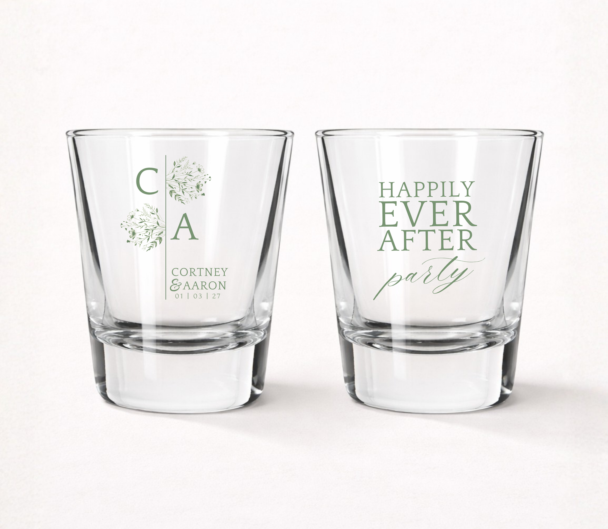 Clear personalized minimalist wedding shot glasses featuring floral initials, custom couple names, Happily Ever After Party design, and wedding date.