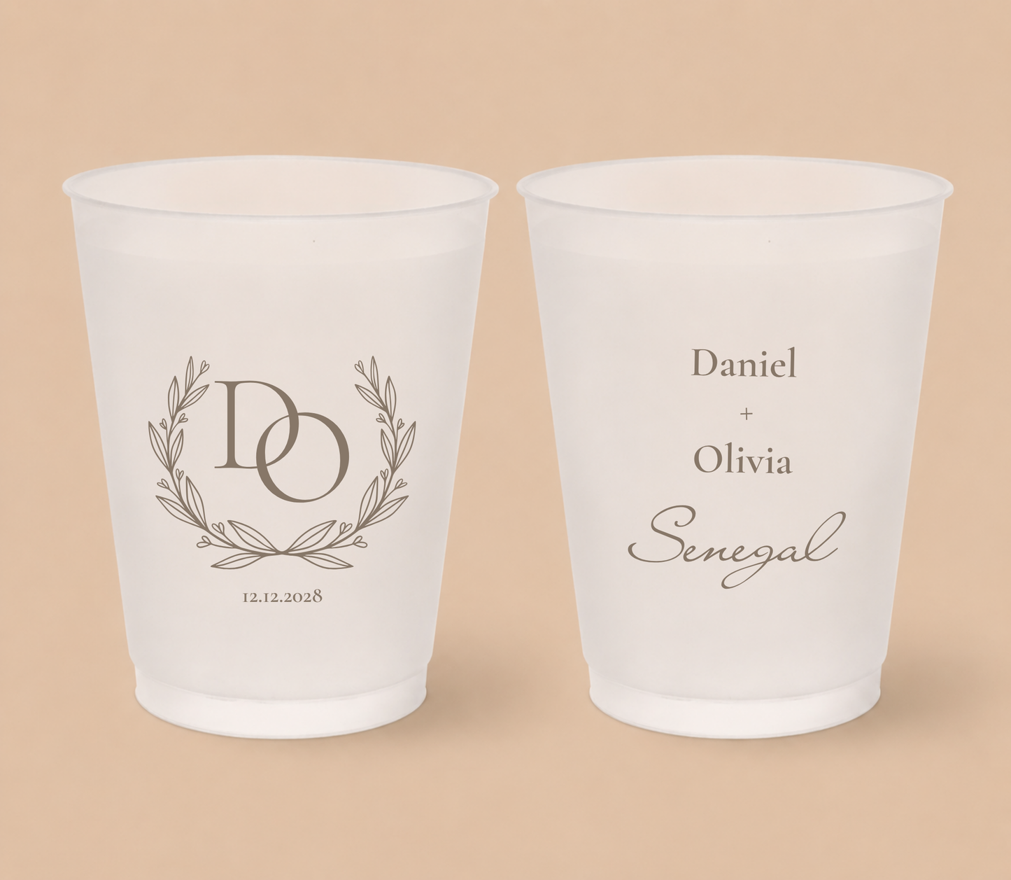 White frosted wedding cups featuring a laurel wreath monogram with intertwined initials DO, couple names Daniel and Olivia, family surname Senegal, and wedding date.
