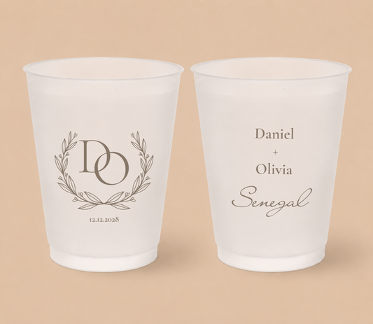 White frosted wedding cups featuring a laurel wreath monogram with intertwined initials DO, couple names Daniel and Olivia, family surname Senegal, and wedding date.
