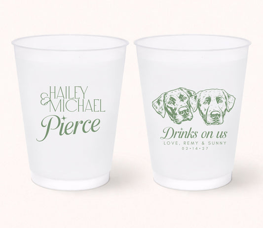 Two personalized frosted wedding cups featuring custom portraits of two dogs, the phrase "Drinks on Us," pet names Remy and Sunny, and personalized couple names Haley and Michael Pierce with the wedding date 02.14.27.
Personalized frosted wedding cups featuring two custom dog portraits and elegant wedding personalization.
Custom wedding drink cups with two pet portraits, couple names, and wedding date.
