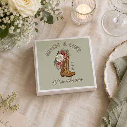 Custom western wedding napkin with floral cowboy boot artwork.
Country wedding cocktail napkin featuring personalized names and cowboy boots.