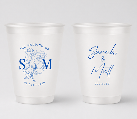 Personalized frosted wedding cups with blue floral monogram artwork for signature cocktails and wedding favors