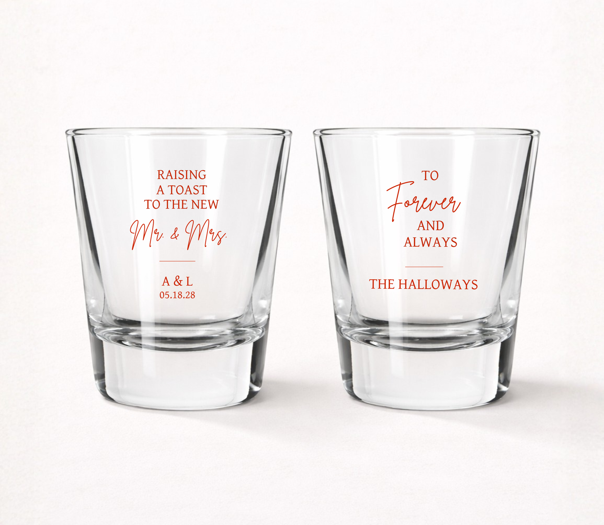 Personalized Raising A Toast wedding shot glasses featuring custom family name, couple initials, wedding date, and elegant Mr. & Mrs. wedding design.