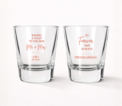 Personalized Raising A Toast wedding shot glasses featuring custom family name, couple initials, wedding date, and elegant Mr. & Mrs. wedding design.