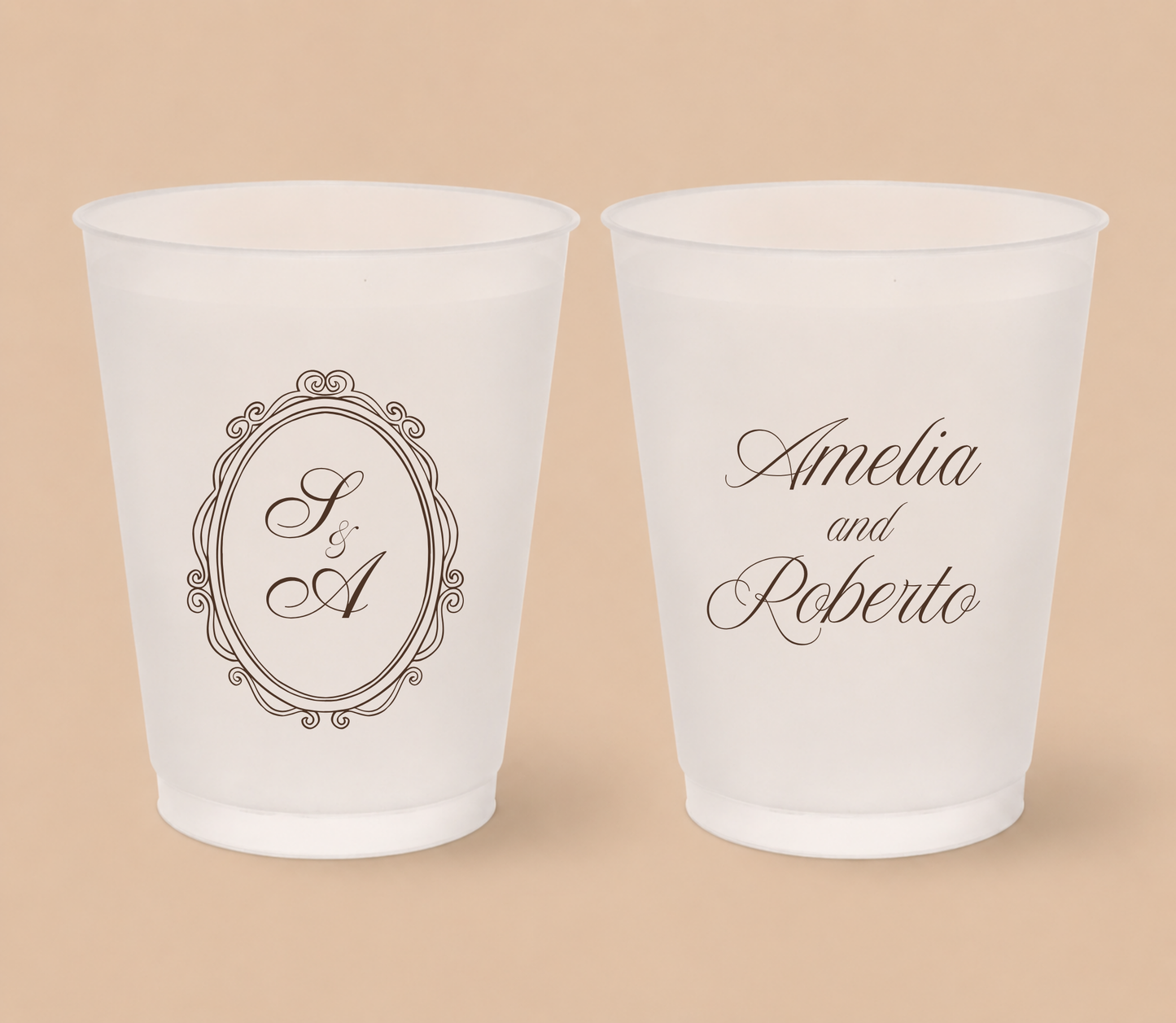White frosted wedding cups featuring a vintage oval crest monogram with custom initials A and R and personalized couple names Amelia and Roberto.
