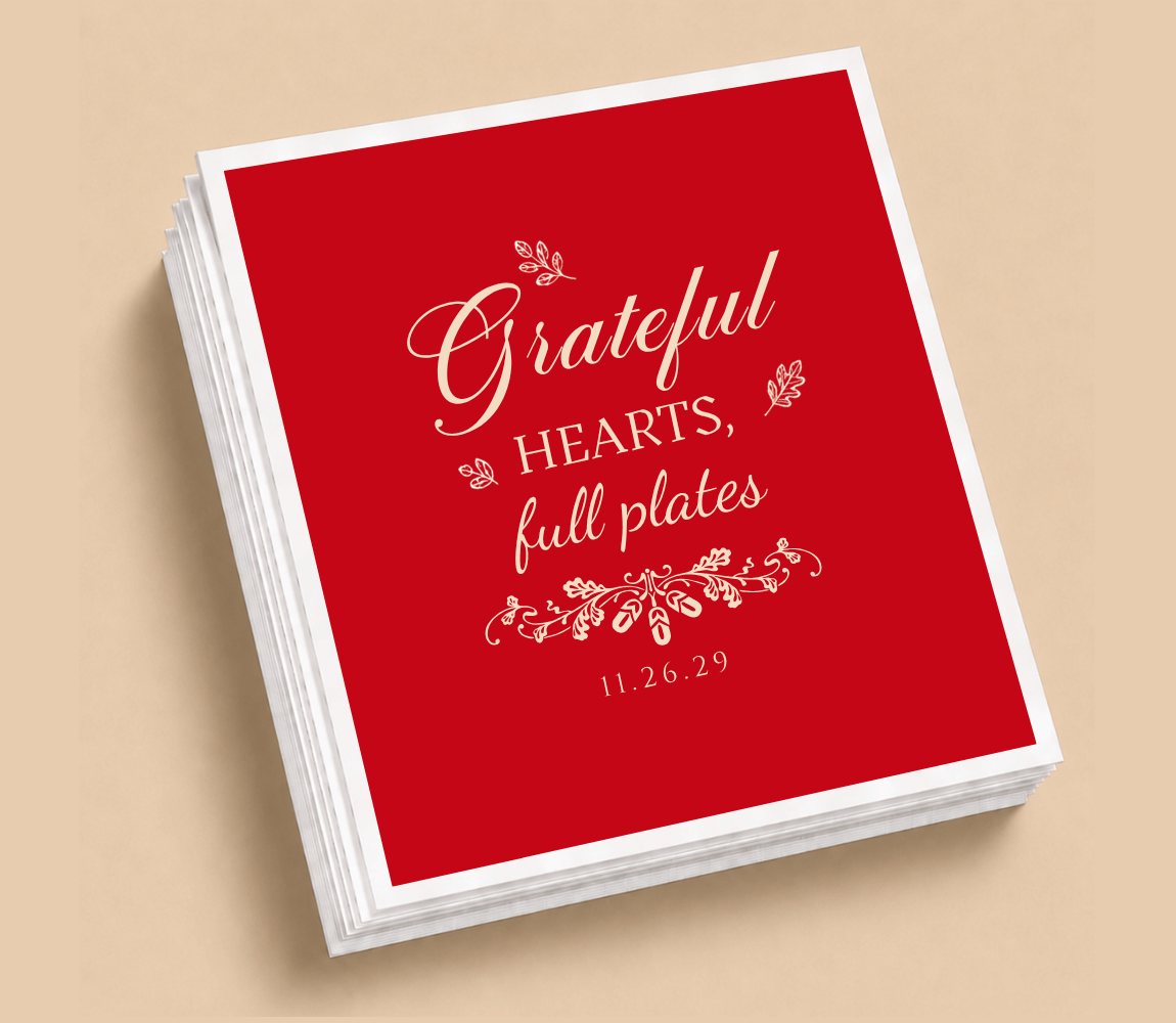 Personalized Thanksgiving wedding table napkins featuring Grateful Hearts Full Plates lettering, botanical accents, and cream artwork on a rich red background.
