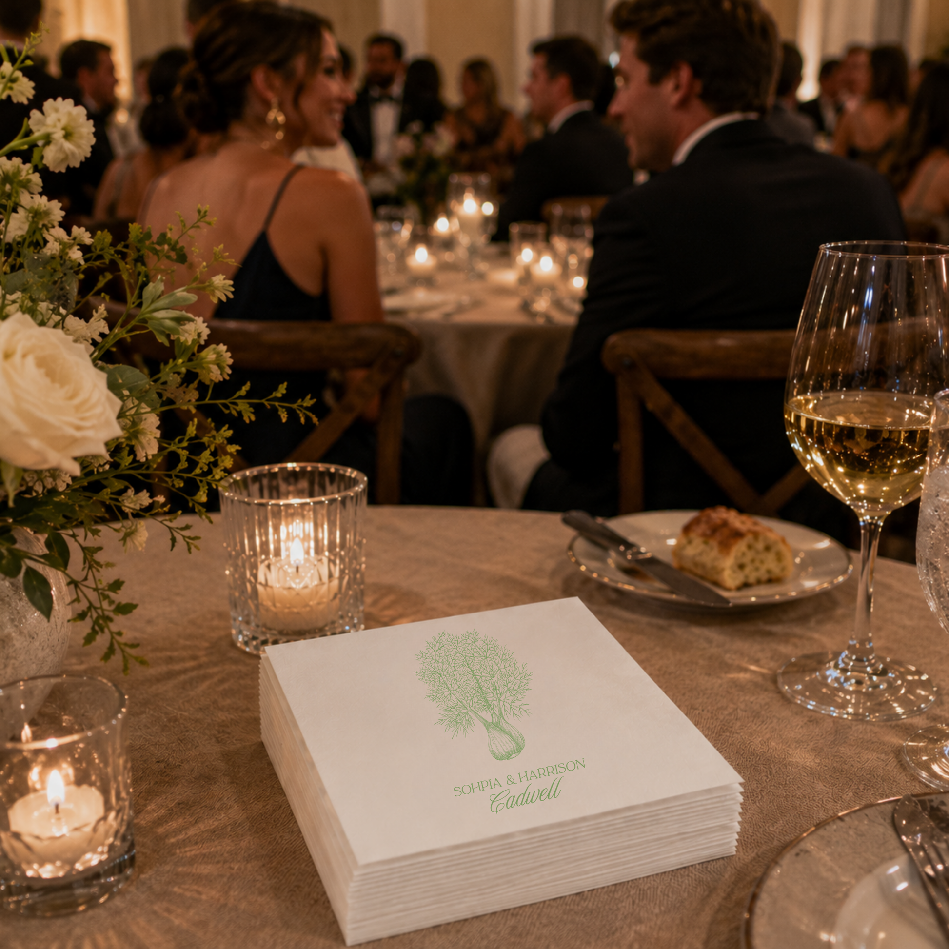 White botanical wedding cocktail napkin featuring elegant greenery artwork and personalized couple names.
