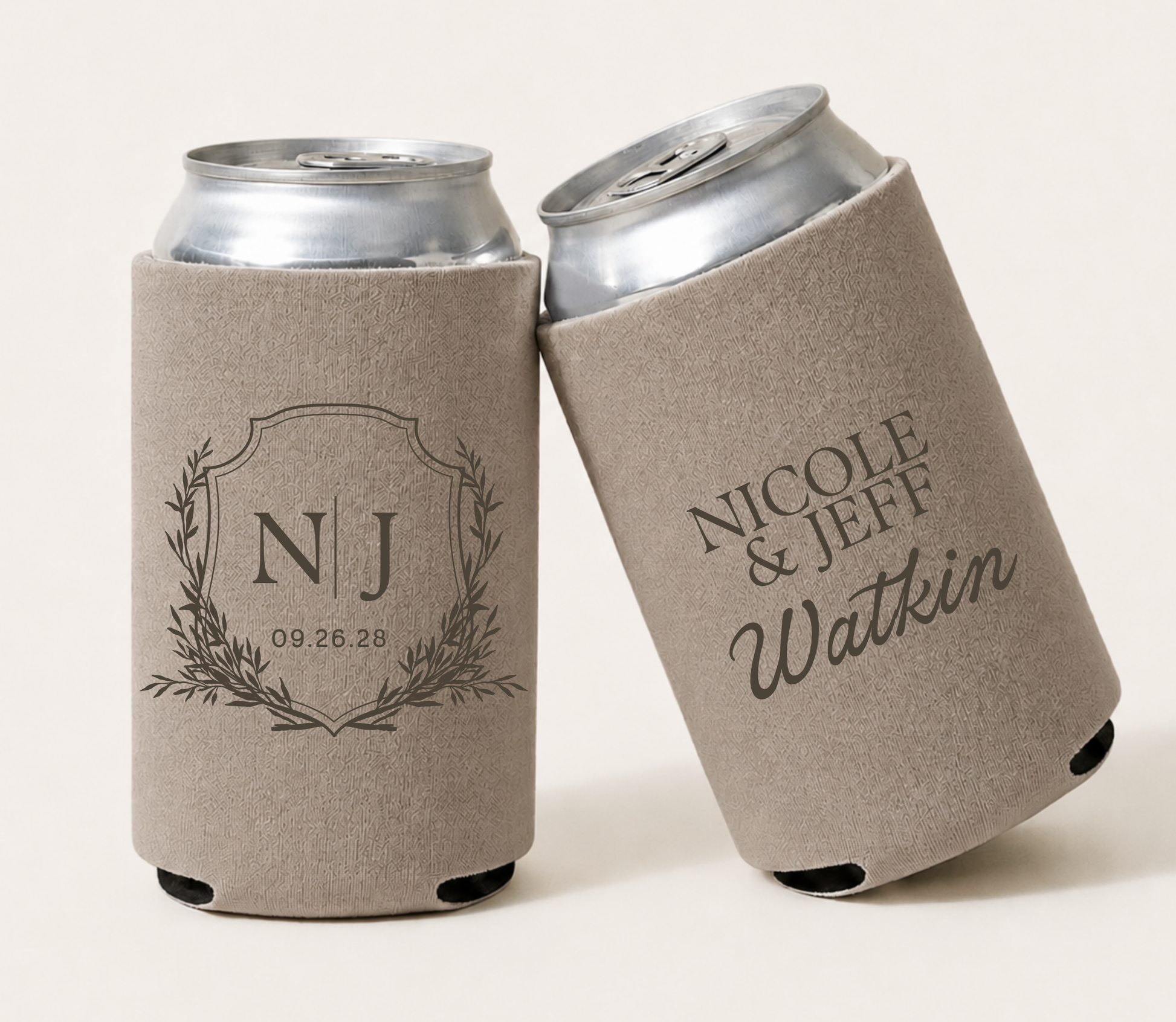 Taupe personalized wedding can coolers featuring an elegant monogram crest, custom initials, couple names Nicole and Jeff, family surname Watkin, and wedding date.