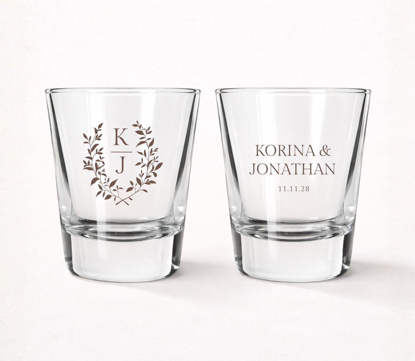 Personalized Korina Laurel Monogram wedding shot glasses featuring custom initials, couple names, wedding date, and an elegant botanical wreath.