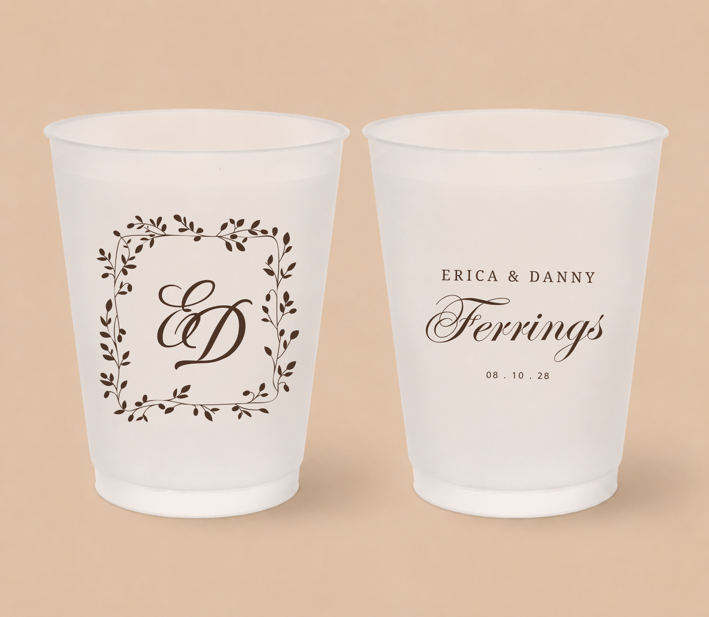 White frosted wedding cups featuring a botanical laurel monogram with initials ED, personalized names Erica and Danny Ferrings, and wedding date.