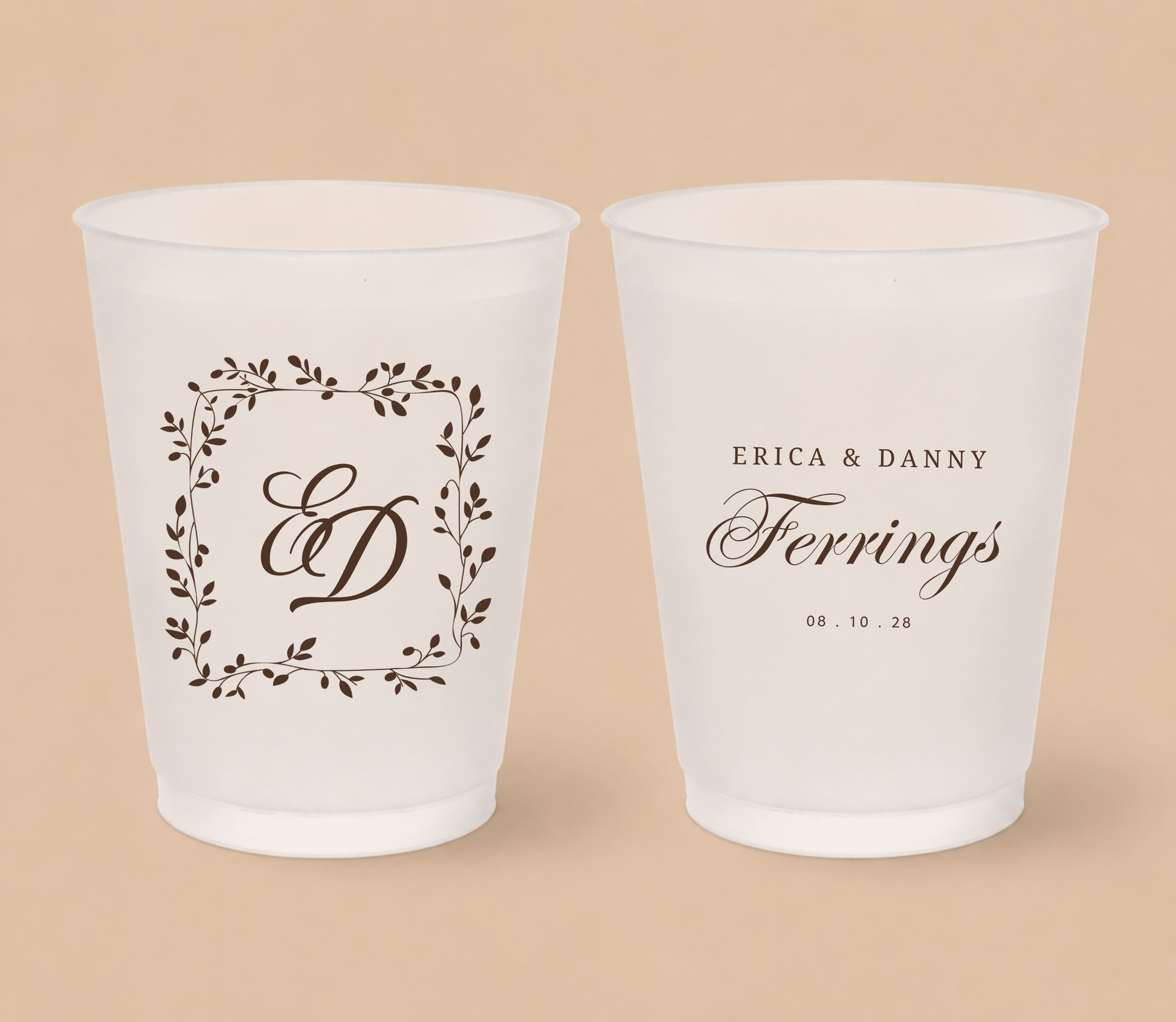White frosted wedding cups featuring a botanical laurel monogram with initials ED, personalized names Erica and Danny Ferrings, and wedding date.