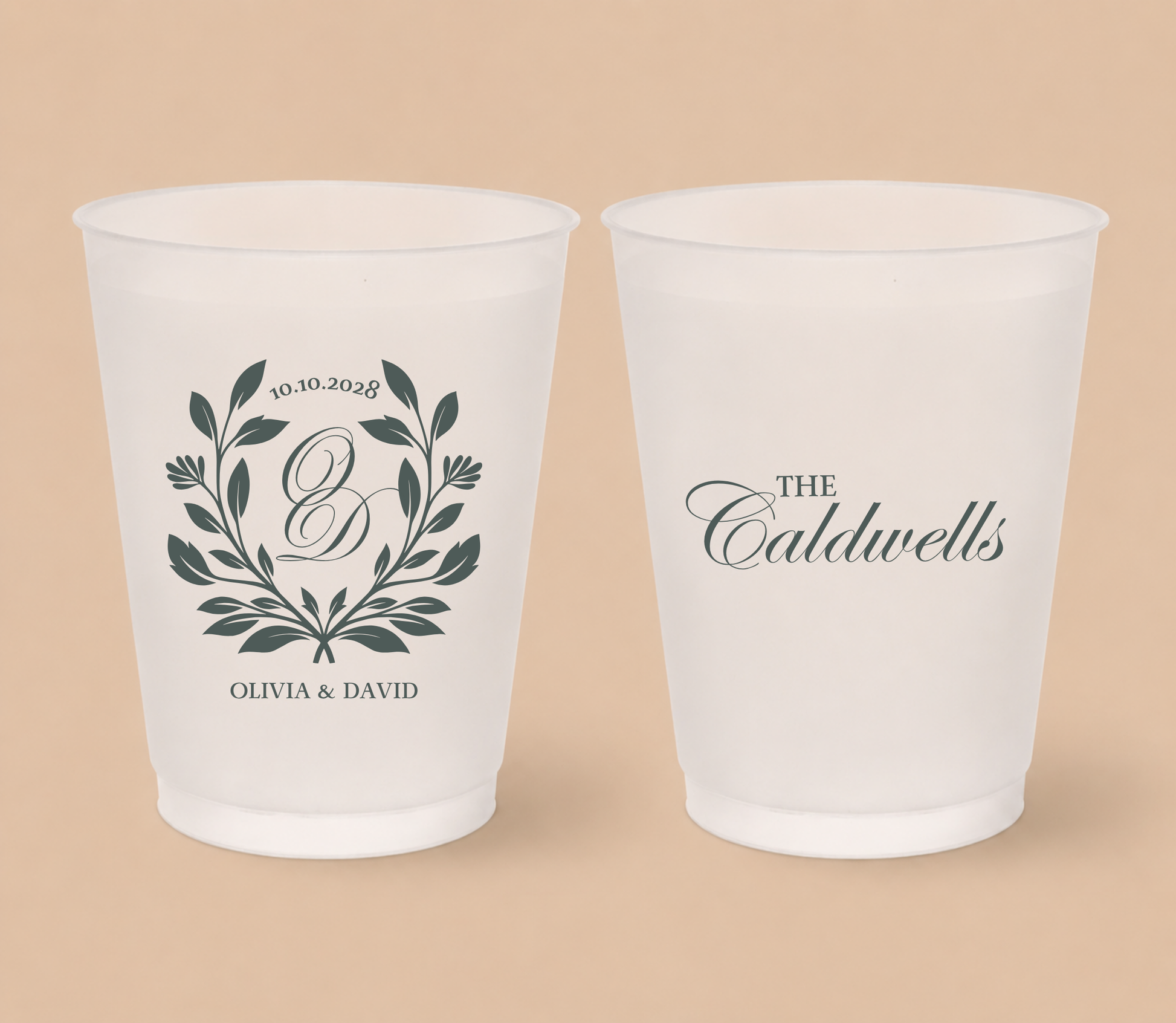 White frosted wedding cups featuring a botanical monogram wreath, custom initial D, couple names Olivia and David, family surname Caldwells, and wedding date.