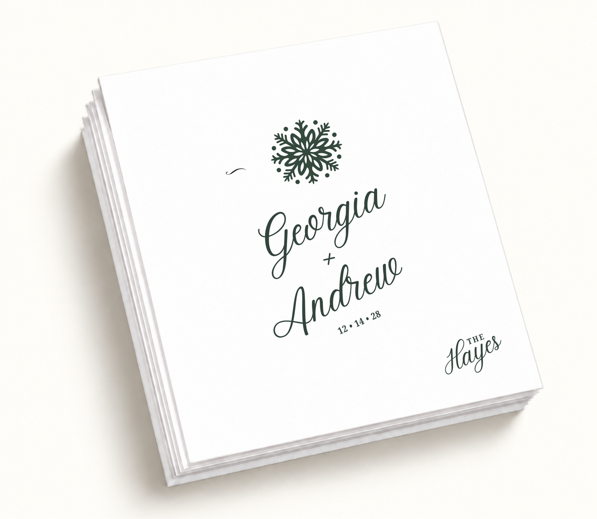 Personalized Georgia And Andrew Christmas wedding napkins featuring deep green snowflake illustration, white background, custom couple names, and wedding date.