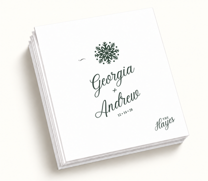 Personalized Georgia And Andrew Christmas wedding napkins featuring deep green snowflake illustration, white background, custom couple names, and wedding date.