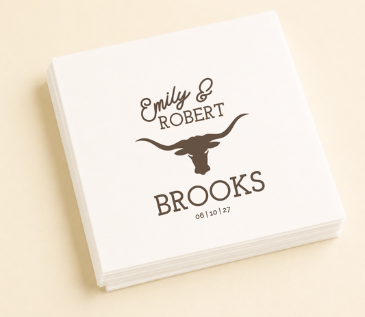 White personalized western wedding cocktail napkin featuring a longhorn silhouette, custom names Emily and Robert, family name Brooks, and wedding date.