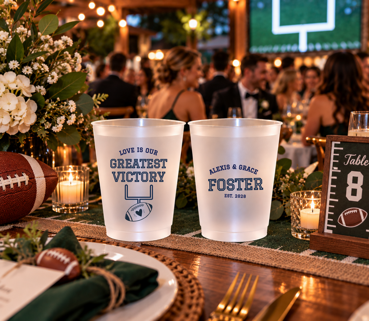 Personalized sports wedding cups with football goalpost artwork, heart detail, and navy athletic lettering.