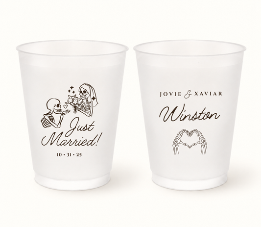 Personalized Just Married frosted wedding cups with a skeleton bride and groom, heart-shaped skeleton hands, couple names, last name, and wedding date.