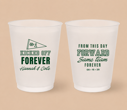 Personalized Kicked Off Forever football wedding cups featuring a #1 pennant, deep green athletic lettering, couple names, and Same Team Forever wedding design.