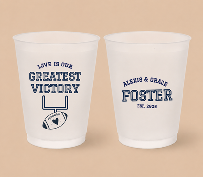 Personalized Greatest Victory football wedding cups featuring Love Is Our Greatest Victory wording, football goalpost artwork, heart detail, and custom couple names.