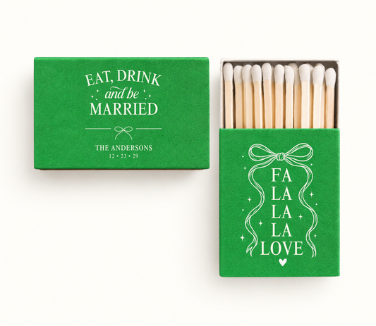 Personalized green Eat Drink And Be Married Christmas wedding matchboxes featuring white bow artwork, Fa La La La Love design, Andersons name, and wedding date.