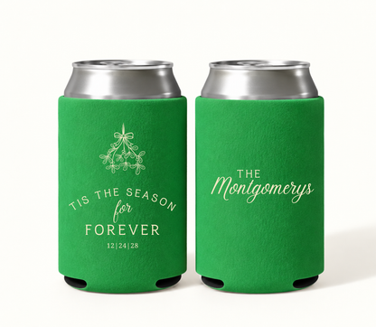 Personalized green Christmas wedding can coolers featuring cream mistletoe artwork, ’Tis the Season for Forever wording, wedding date 12.24.28, and The Montgomerys family surname.