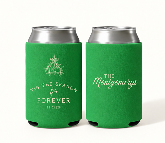 Personalized green Christmas wedding can coolers featuring cream mistletoe artwork, ’Tis the Season for Forever wording, wedding date 12.24.28, and The Montgomerys family surname.