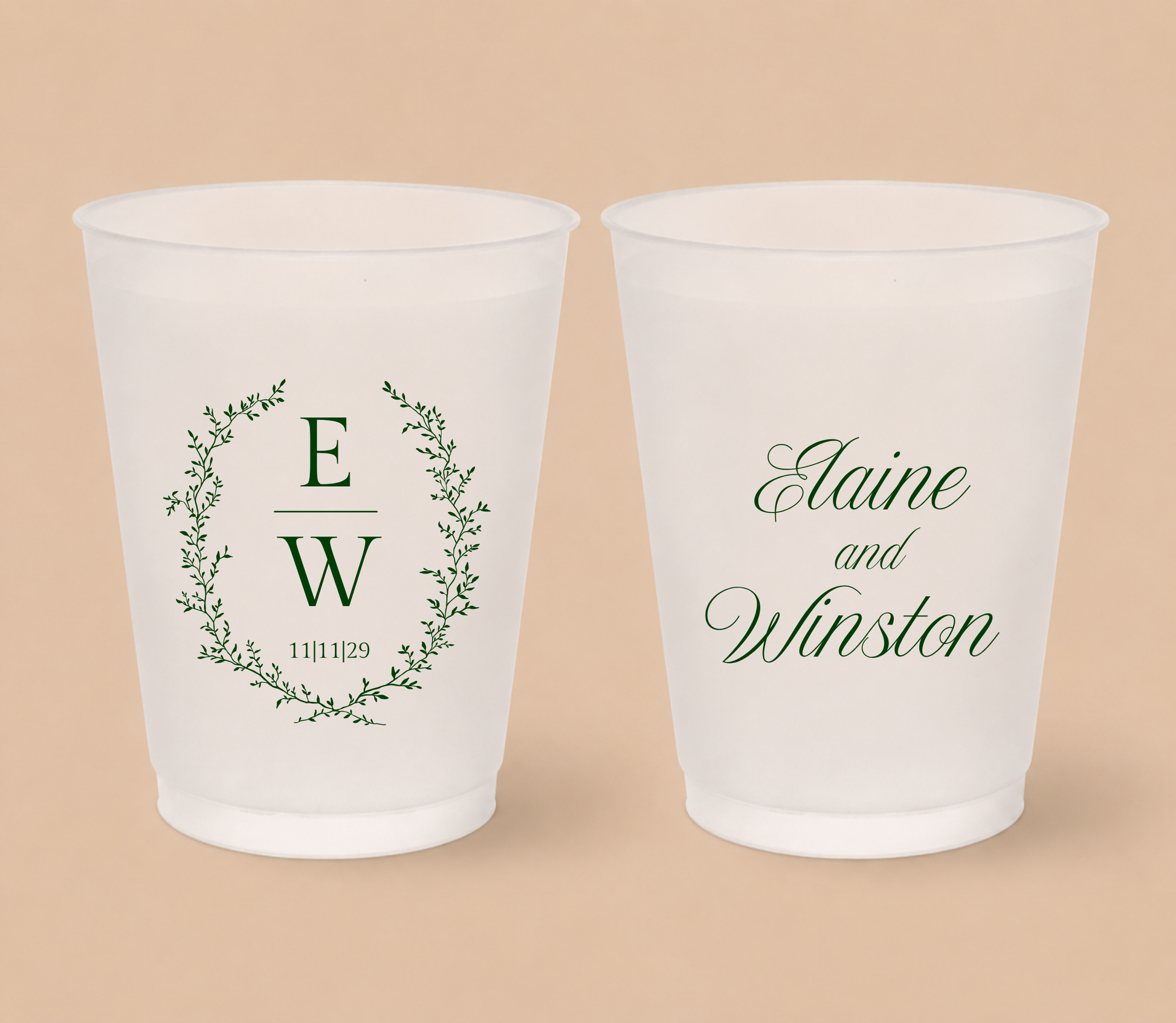 White frosted wedding cups featuring a botanical greenery wreath with custom initials E and W, wedding date, and personalized names Elaine and Winston.