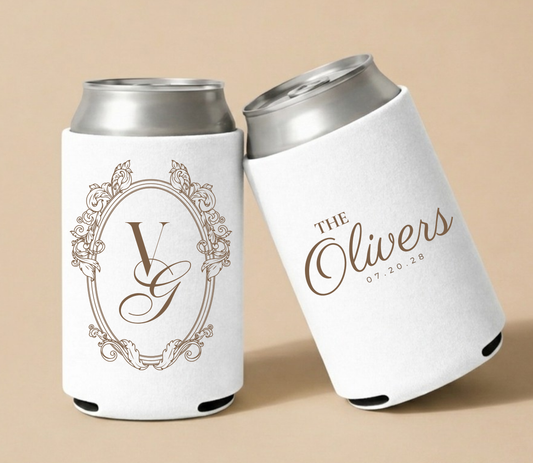 White personalized foam wedding can coolers featuring an ornate vintage monogram with initials VG, family name The Olivers, and wedding date July 20, 2028.
