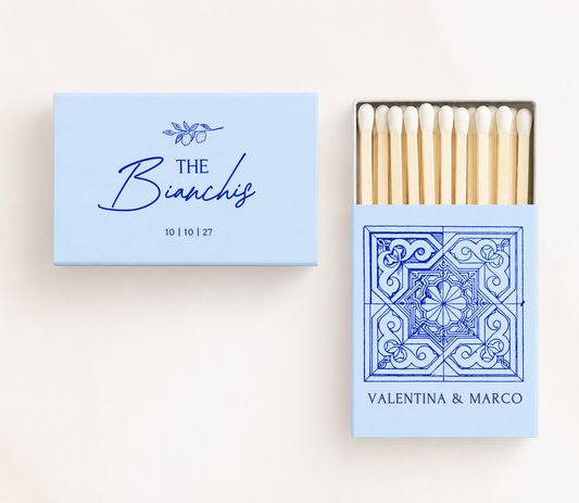 Personalized Italian tile wedding matchboxes featuring a Mediterranean ceramic tile illustration, custom names, family name, and wedding date.