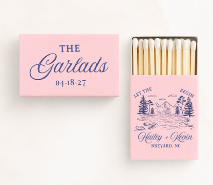 Personalized "Let The Adventure Begin" wedding matchboxes featuring custom family name, couple names, wedding location, date, and mountain landscape illustration.